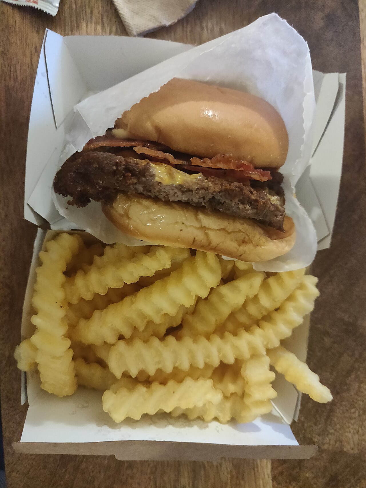 Hamburguesa con tocino y papas fritas